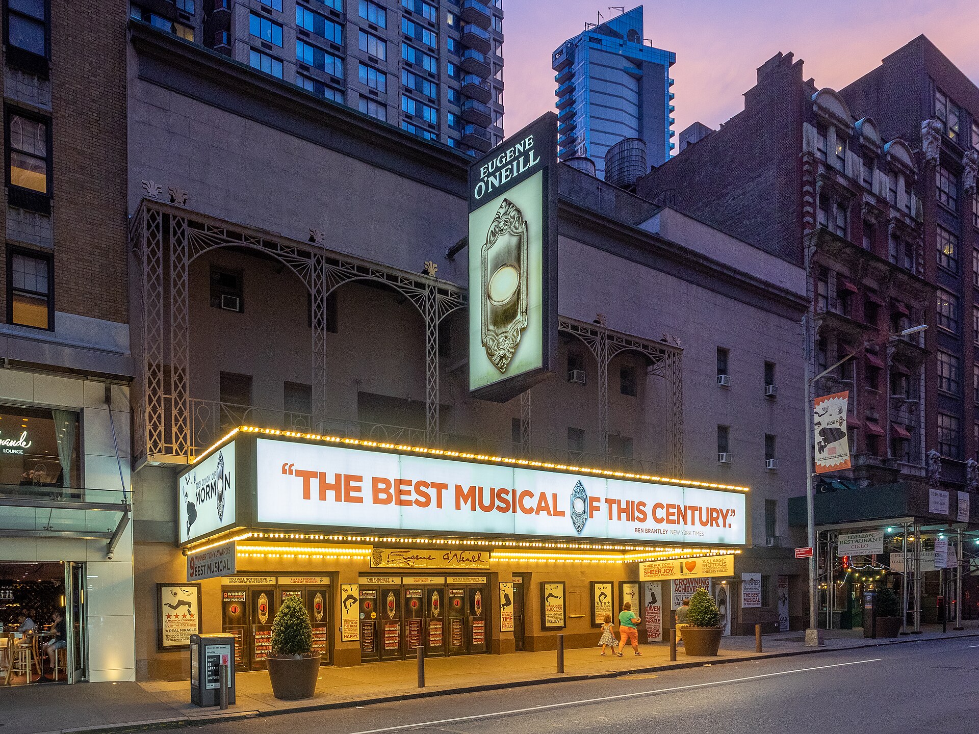 Illuminated marquee of the Eugene O'Neill Theatre on West 49th Street in New York City's Theater District at dusk, advertising The Book of Mormon
