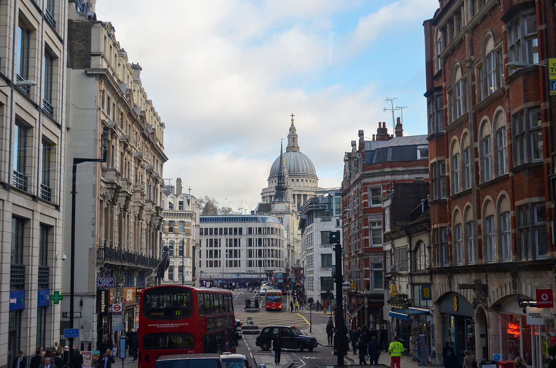 Fleet Street in London with a red double-decker bus and the dome of St Paul's Cathedral in the distance