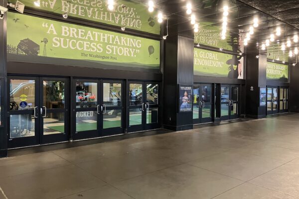 Entrance of the Gershwin Theatre in New York with green Wicked banners above the doors