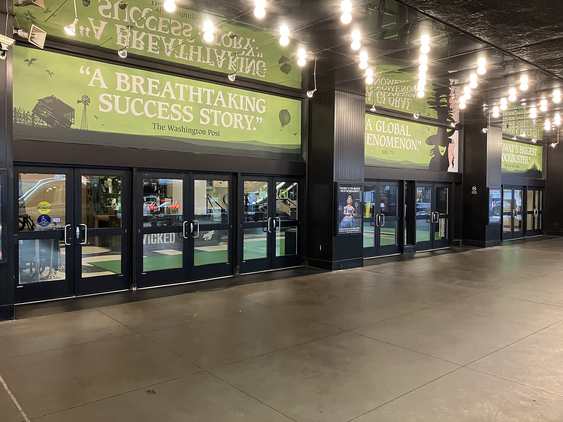 Entrance of the Gershwin Theatre in New York with green Wicked banners above the doors
