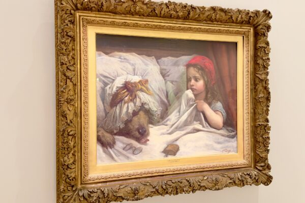 Gustave Doré painting of Little Red Riding Hood in bed beside the wolf disguised as her grandmother