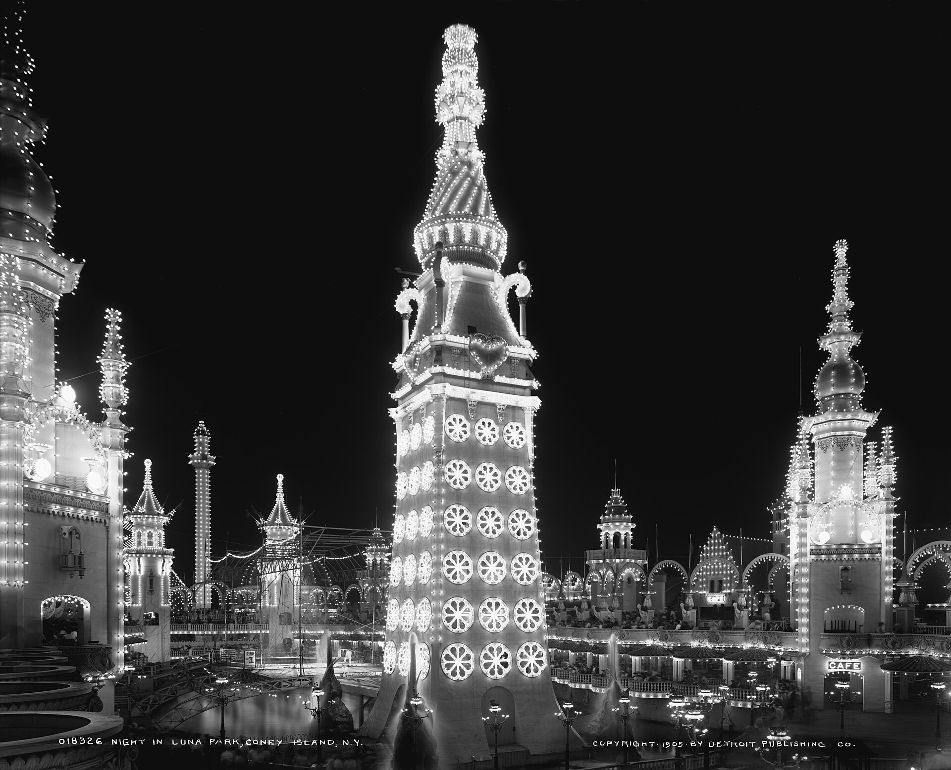 Black-and-white photograph of Luna Park at Coney Island around 1905, its towers outlined in electric lights at night